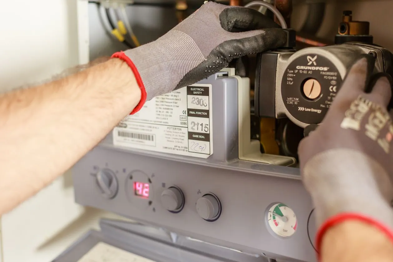 Heating technician performing seasonal furnace maintenance